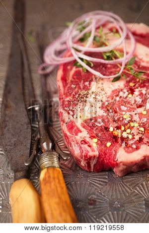 beef steak t-bone with vintage meat fork on metal backdrop