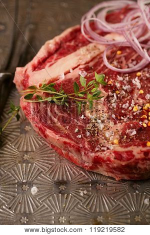 beef steak t-bone with vintage meat fork on metal backdrop