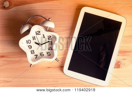 Education Concept. Top View Alarm Clock On Wood Table With Tablet Pc, Vintage Tone