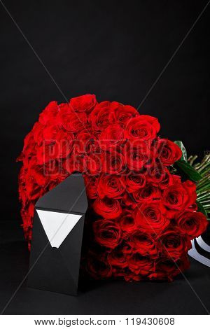 101 Bouquet Of Red Roses With A Black Envelope For A Logo, On A Black Studio Background, Spring Is C