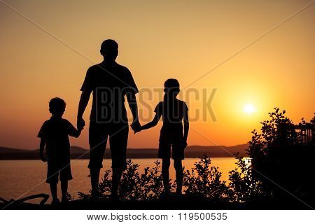 Father And Children Playing On The Coast Of Lake
