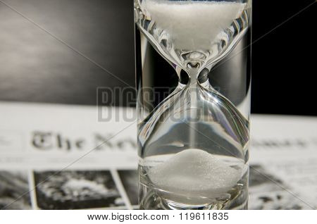 Completely Filled Sandglass On Newspaper