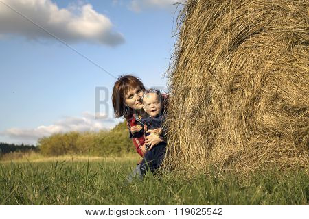 Little Girl And Her Mother By The Haystack