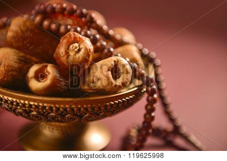 Religious food and objects. Close up of arabic dates and rosary.