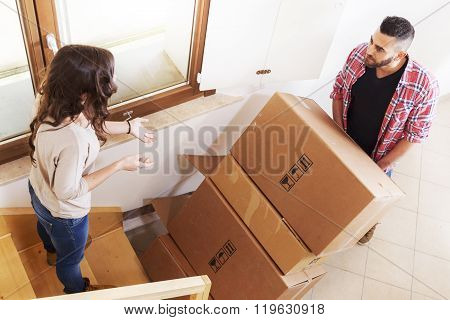 Young Couple Carrying The Boxes In New House