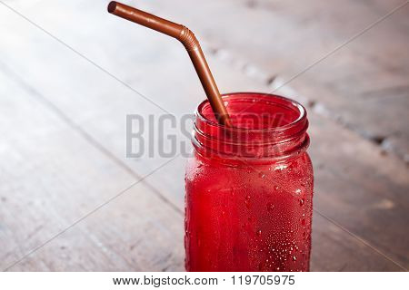 Iced Drink In Red Glass On Wooden Table