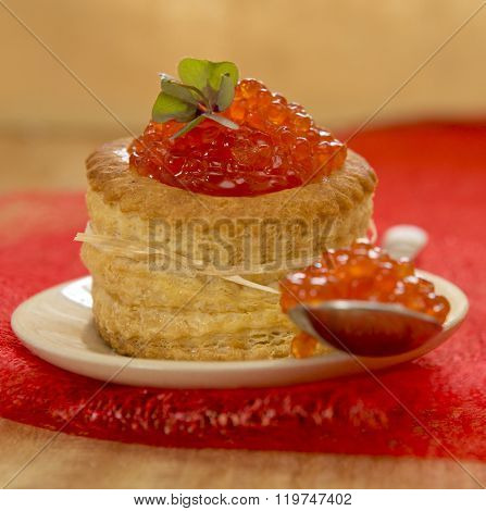 Tartlet with red caviar on plate.