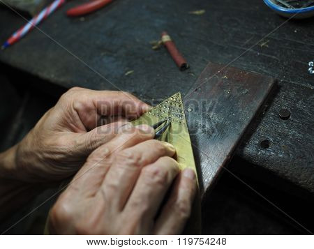 Goldsmith working on an unfinished gold with his hard working hands