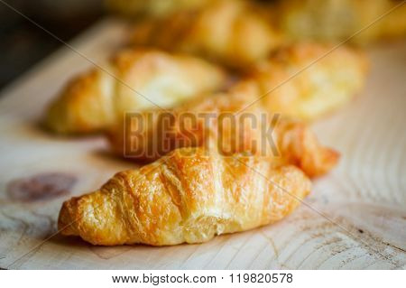 Black Croissants With Black Coffee On Wooden Background