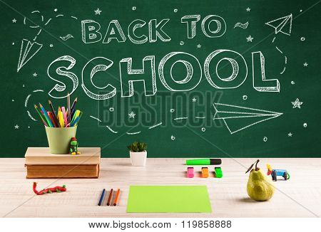 Back to school concepty with writing on blackboard and desk, apple, books, items