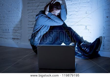 sad and scared female teenager with computer laptop suffering cyberbullying and harassment being online abused by stalker or gossip feeling desperate and humiliated in cyber bullying concept
