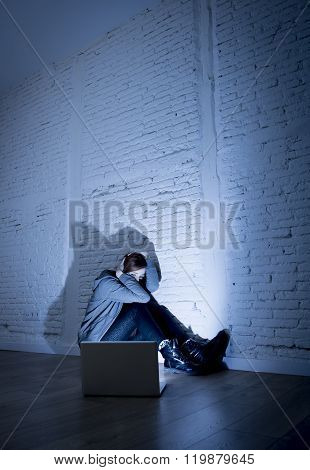 sad and scared female teenager with computer laptop suffering cyberbullying and harassment being online abused by stalker or gossip feeling desperate and humiliated in cyber bullying concept