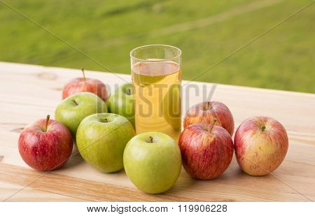 apples and apple juice on a wooden table, outdoor
