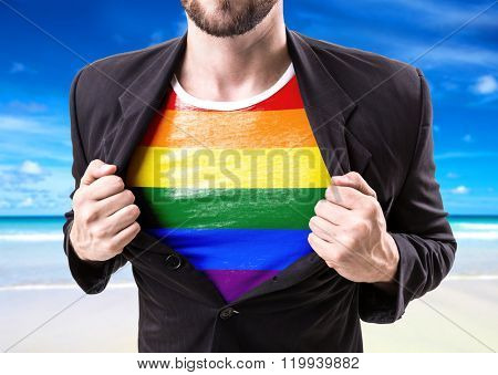 Businessman stretching suit with Rainbow Flag (LGBT Movement) with beach background
