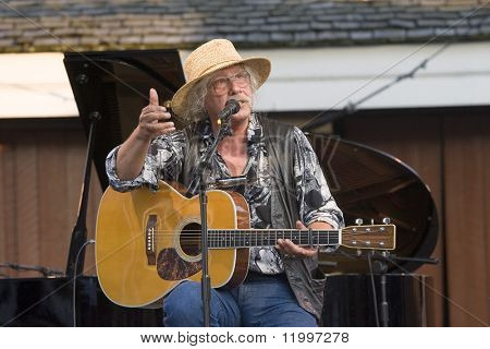 Nowy Jork - 30 lipca: Muzyk Arlo Guthrie gestów, jak on wykonuje w parku Battery Castle Clinton o