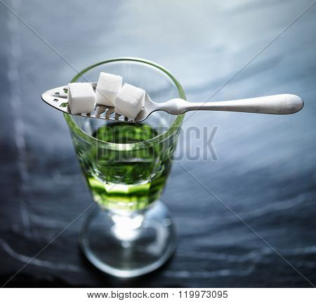 absinthe in pontarlier glass with spoon and sugar cubes