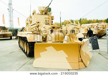 Nizhniy Tagil, Russia - September 25. 2013: Visitors examine military equipment on exhibition range. On foreground Combat engineering vehicle IMR-2MA. RAE-2013 exhibition