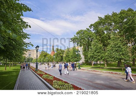 MOSCOW, JUN. 29, 2017: View on Moscow Kremlin Red Square Alexandrovskiy garden park with green trees flowers and walking people tourists.