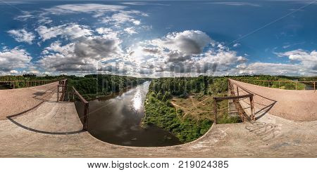 full 360 degree seamless panorama in equirectangular spherical equidistant projection. Panorama view on abandon bridge near river with nice clouds. Skybox as background for virtual reality content