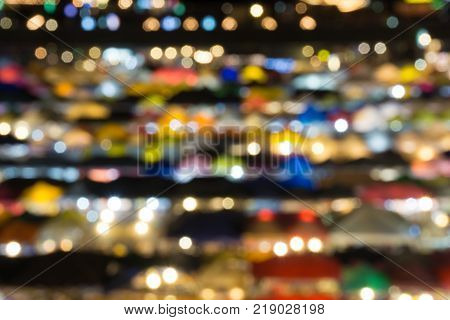 defocused of multi color light and plastic roof of ratchada train night marketbangkok. for christmas and new year abstract background concept.
