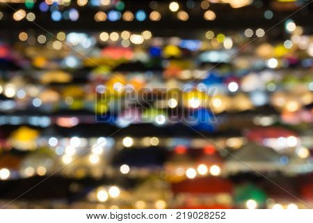 defocused of multi color light and plastic roof of ratchada train night marketbangkok. for christmas and new year abstract background concept.