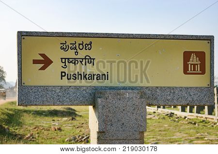 Hampi, India - November 20, 2012: Signpost for tourists about Pushkarani market complex near temple tank on the way to the Vitthala temple, Hampi, Karnataka, India.