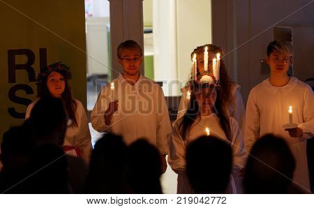STOCKHOLM SWEDEN - DEC 13 2017: Lucia parade with singing girls and boys in white dresses holding candles. Traditional celebration of the suffering of saint Lucia from Italy in Stockholm Sweden December 13 2017