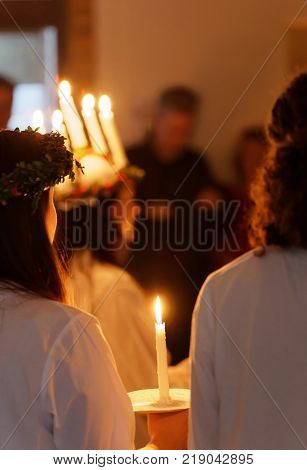 STOCKHOLM SWEDEN - DEC 13 2017: Lucia parade with singing girls and boys in white dresses holding candles. Traditional celebration of the suffering of saint Lucia from Italy in Stockholm Sweden December 13 2017