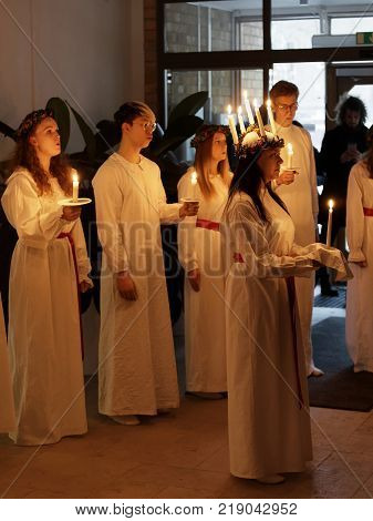 STOCKHOLM SWEDEN - DEC 13 2017: Lucia parade with singing girls and boys in white dresses holding candles. Traditional celebration of the suffering of saint Lucia from Italy in Stockholm Sweden December 13 2017