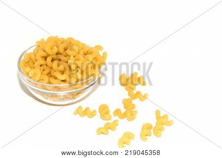 Dried raw, uncooked spirelli pasta noodles backlit in glass container isolated on white background, space for text.