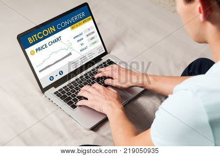 Bitcoin trading website. Man using a laptop to trade bitcoin price by internet.