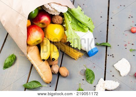Grocery Shopping Concept. Different Food In Paper Bag On Wooden Background.  Flat Lay.