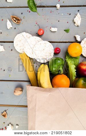 Grocery Shopping Concept. Different Food In Paper Bag On Wooden Background.  Flat Lay.
