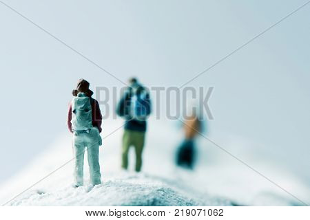 some different miniature hikkers in a snowcapped mountain on winter time