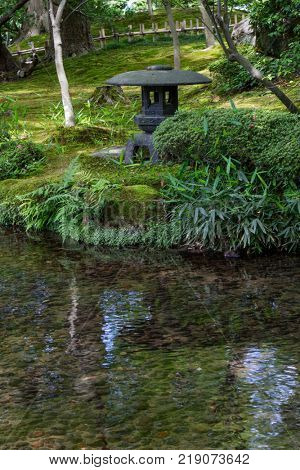 Kanazawa - Japan, June 9, 2017: Historical stone lantern in Gyokuseninmaru Garden at Kanasawa castle in springtime