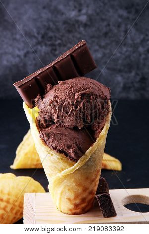 chocolate ice cream scoops with pieces of chocolate and waffle cones