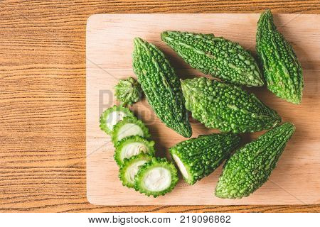 Bitter melon or bitter gourd on wooden tray. Free space for taxt