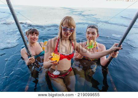 Novokuznetsk, Kemerovo region, Russia - 23 Feb, 2017 : White beaches of Siberia is an enterteiment activity where people playing beach games dressed in bikini in winter. Women in ice hole with drinks