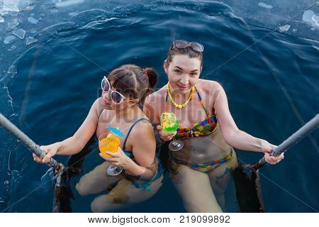 Novokuznetsk, Kemerovo region, Russia - 23 Feb, 2017 : White beaches of Siberia is an enterteiment activity where people playing beach games dressed in bikini in winter. Women in ice hole with drinks