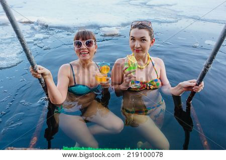 Novokuznetsk, Kemerovo region, Russia - 23 Feb, 2017 : White beaches of Siberia is an enterteiment activity where people playing beach games dressed in bikini in winter. Women in ice hole with drinks