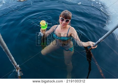 Novokuznetsk, Kemerovo region, Russia - 23 Feb, 2017 : White beaches of Siberia is an enterteiment activity where people playing beach games dressed in bikini in winter. Woman in an ice hole