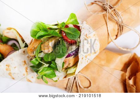 Fresh tortilla wraps rolled in a brown paper and tied round with string. Gourmet concept.