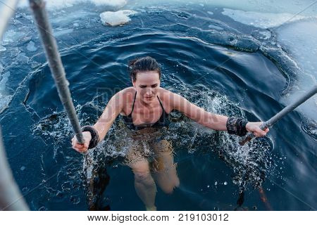 Novokuznetsk, Kemerovo region, Russia - 23 Feb, 2017 : White beaches of Siberia is an enterteiment activity where people playing beach games dressed in bikini in winter. Woman in an ice hole