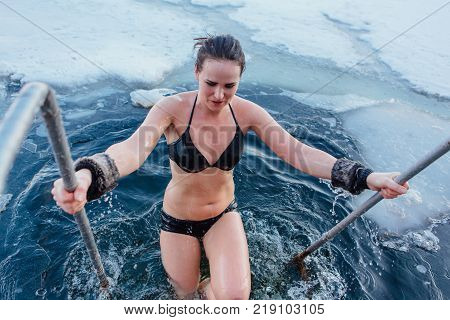 Novokuznetsk, Kemerovo region, Russia - 23 Feb, 2017 : White beaches of Siberia is an enterteiment activity where people playing beach games dressed in bikini in winter. Woman in an ice hole