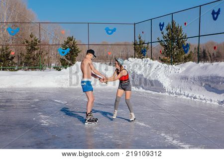 Novokuznetsk, Kemerovo region, Russia - 23 Feb, 2017 : White beaches of Siberia is an enterteiment activity where people playing beach games dressed in bikini in winter. Couple in shorts on ice skates