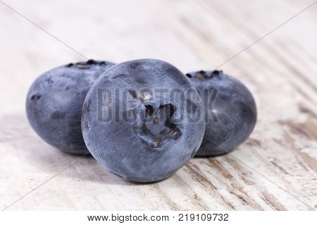 Fruits of northern highbush blueberry (Vaccinium corymbosum) on a wooden board close up