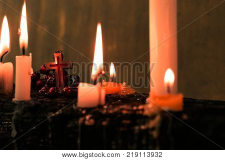 Candles on an old wooden burnt table. Beautiful dark background. Religious concept.