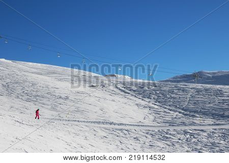 Snowboarder downhill on ski at cold sun morning. Georgia region Gudauri. Caucasus Mountains in winter.