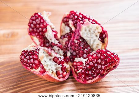 Big red pomegranate on the wooden board. Ripe granet fruit. Broken pomegranate.