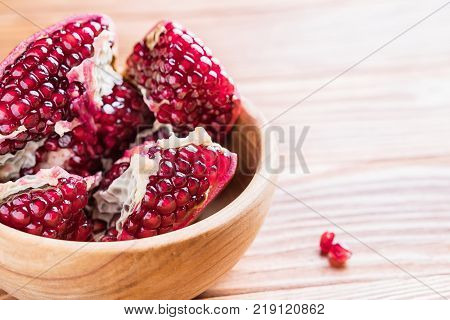 Big red pomegranate on the wooden board. Ripe granet fruit. Broken pomegranate.
